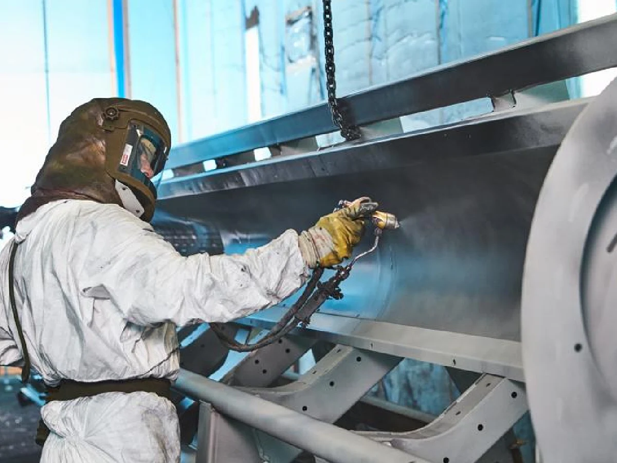 large-metal-parts-powder-coating-spraying-workshop - likundacnc.com 工人穿戴防护装备对大型 CNC 金属结构件进行粉末喷涂防锈表面处理
